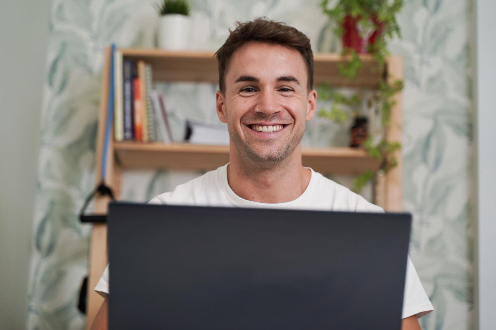 笑顔で楽しそうにパソコンを見ている男性